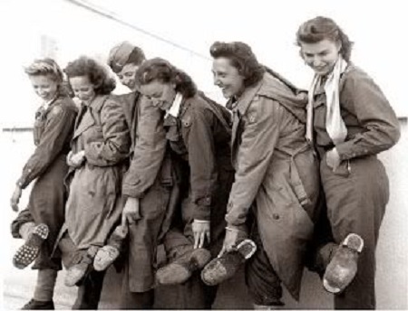 Flight nurses of the 807th Medical Air Evacuation Transport Squadron show their worn-out shoes after returning to Italy, 9 January 1944.
