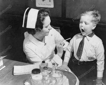 Nurse asking a young patient to open his mouth.