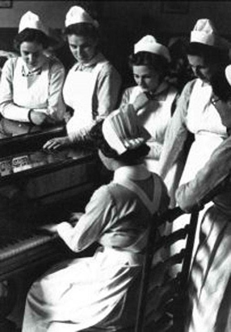 Nurses gather around a Piano, circa 1940